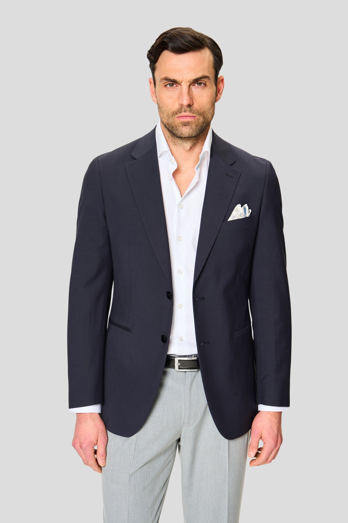 Mand i mørkeblå enkeltradet blazer med grå bukser og hvid skjorte